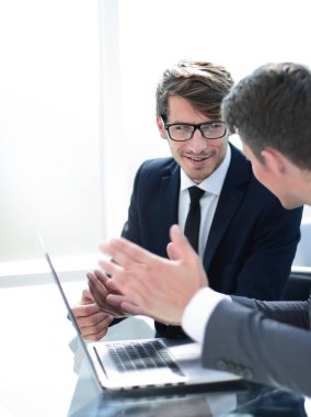 Ofis masasında oturarak online bilgi tartışan çalışanlar