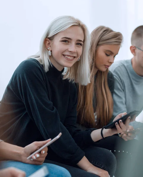 De près. femme avec smartphone assis parmi ses amis — Photo