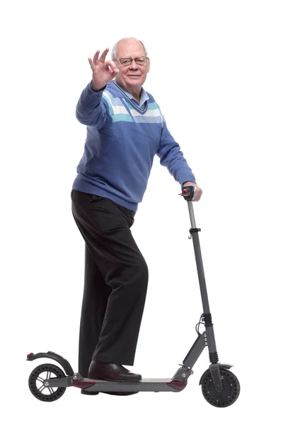 Vista lateral. um homem idoso com uma scooter elétrica apontando para você — Fotografia de Stock