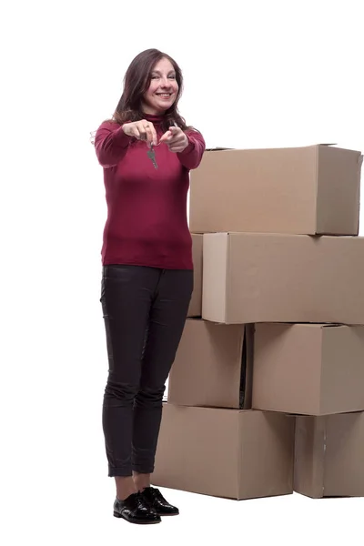 Donna felice con chiavi in piedi vicino a scatole di cartone — Foto Stock