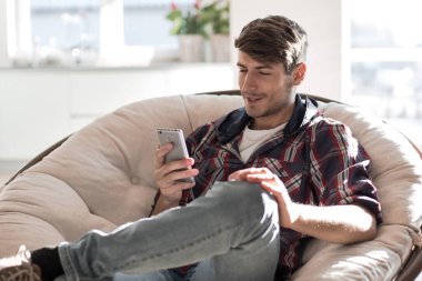 Akıllı telefonuyla SMS okuyan başarılı genç adam.