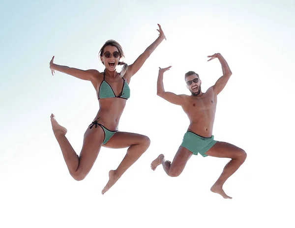 Pareja feliz saltando en la playa. — Foto de Stock