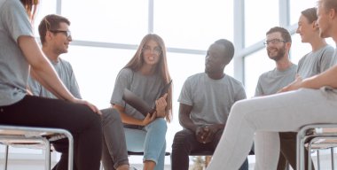 Gülümseyen hoparlörler bir grup gencin arasında oturuyor.