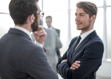 İş arkadaşları iş merkezinin lobisinde konuşuyor.