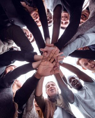 Alt manzara. Bir grup mutlu genç insan el ele tutuşuyor.