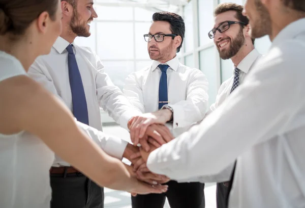 Крупним планом. усміхнена бізнес команда стоїть зі складеними руками разом . — стокове фото