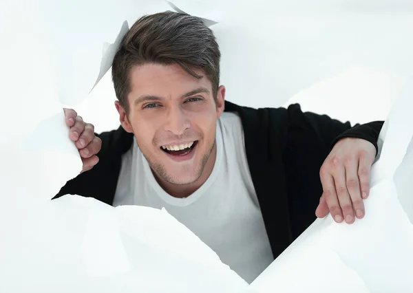 Joven hombre de negocios rompiendo una pared de papel. — Foto de Stock