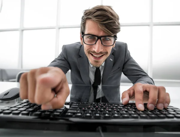 Homem apontando para algo com o dedo e usando teclado do computador — Fotografia de Stock