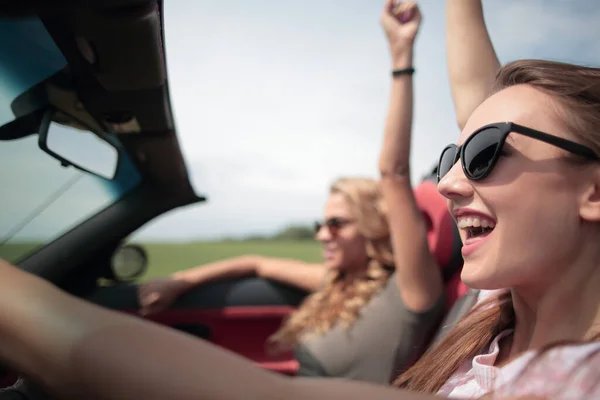 Close up.two mujeres jóvenes que viajan en un coche — Foto de Stock