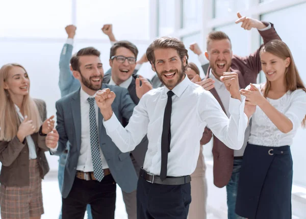 Felice giovane uomo d'affari in piedi davanti al suo team di lavoro — Foto Stock