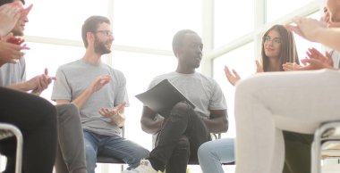 Gülümseyen hoparlörler bir grup gencin arasında oturuyor.