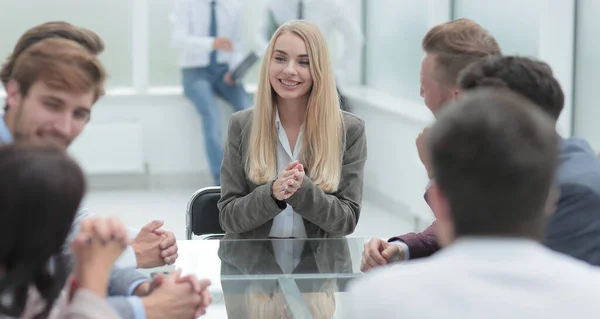 Jonge zakenvrouw bespreekt haar ideeën met een business team. — Stockfoto
