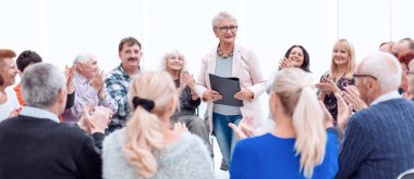 Yaşlı kadın yaşlılara öğretiyor.