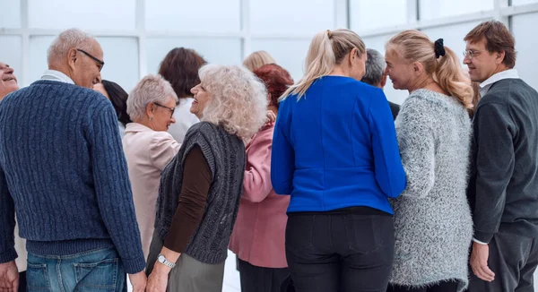 Група людей похилого віку, що стоять зі спинами в приміщенні — стокове фото