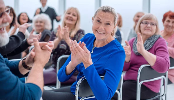 En grupp äldre människor sitter i en cirkel klappar — Stockfoto