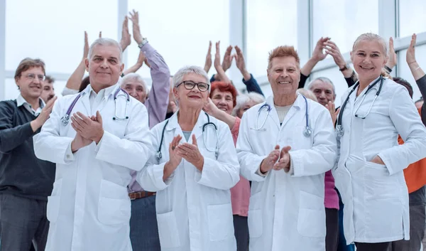 Doktorlar ve bir grup olgun insan alkışlıyor. — Stok fotoğraf