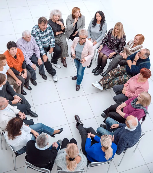 Zelfverzekerde oudere vrouw die in een kring van gelijkgestemden staat — Stockfoto