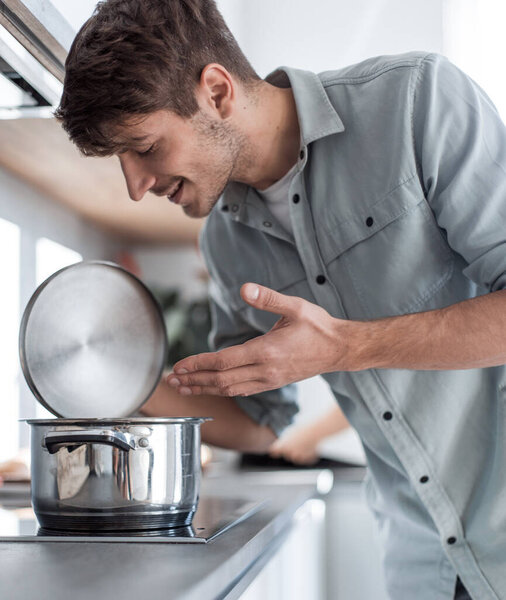 close up. young man looking into the pan.
