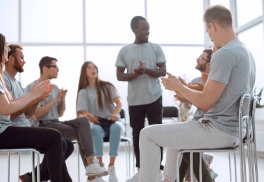 Seminer dinleyicileri çemberinde duran genç bir kadın.