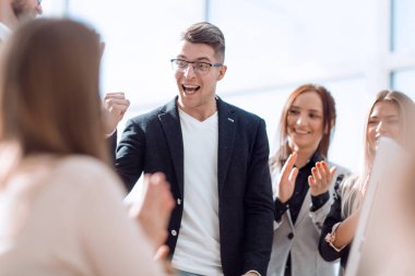 Mutlu lider iş ekibinin önünde duruyor.