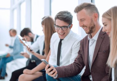 Ofis koridorunda oturan bir grup iş adamı..