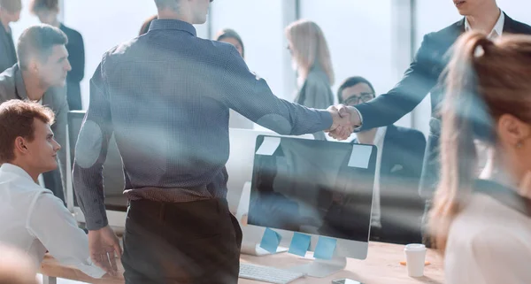 A través del vidrio. jóvenes empresarios, estrechando con confianza las manos. — Foto de Stock