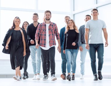 Bir grup mutlu genç çalışan yeni bir ofise giriyor.