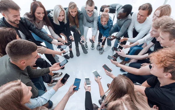 De cerca. grupos de jóvenes con smartphones sentados en círculo — Foto de Stock