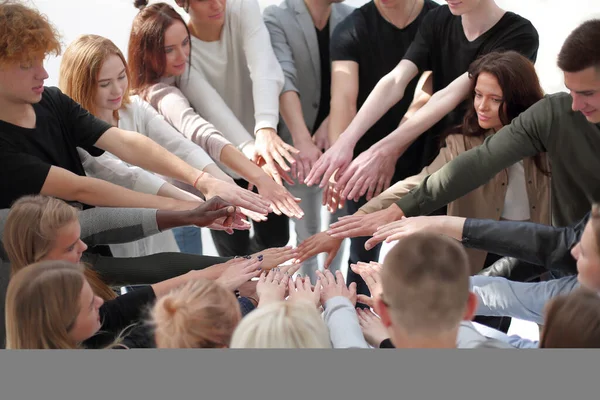 group of diverse people joining their hands in a circle.