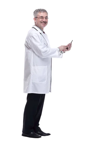 Smiling doctor with smartphone looking forward. isolated on a white — Stock Photo, Image