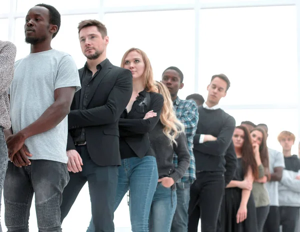 Grupo de jóvenes serios que hacen cola. — Foto de Stock