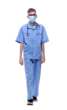 Tam gelişim. Koruyucu maskeli ciddi bir doktor ileriye doğru ilerliyor. .