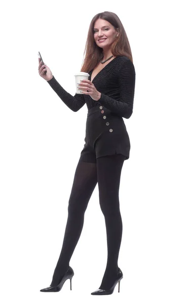 타키 웨이 커피를 마시며 스마트폰으로 문자 메시지를 읽고 있는 젊은 여성. — 스톡 사진