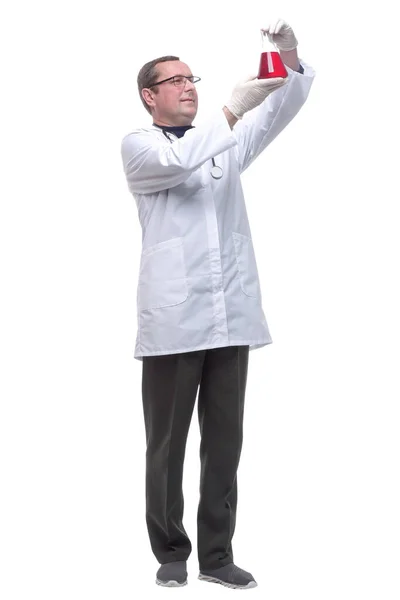 Зрелый врач смотрит на жидкость в лабораторной фляжке . — стоковое фото