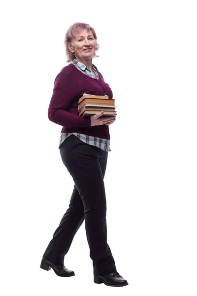 Femme mûre avec une pile de livres allant de l'avant. isolé sur un blanc — Photo