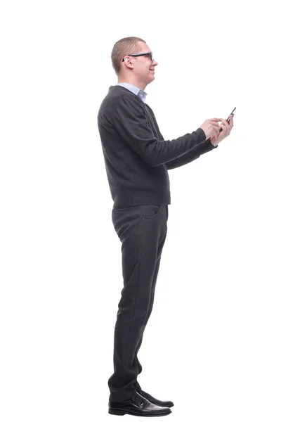 Casual young man is pointing to his side while speaking on the phone and smiling to the camera — Stock Photo, Image