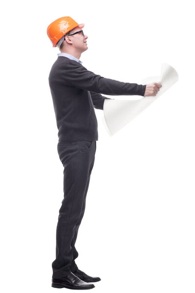 sideview full length portrait of serious businessman in orange hardhat with blueprint looking up