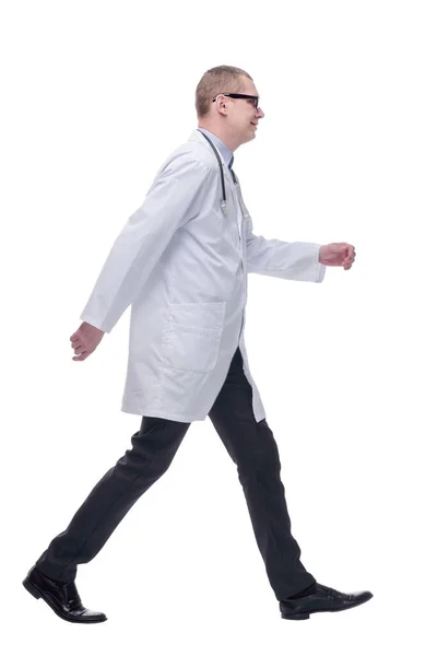 Walking young male doctor wearing glasses and stethoscope around the neck, side view — Stock Photo, Image