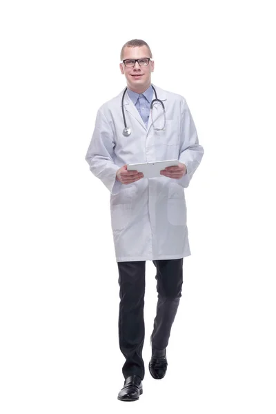 Portrait of male doctor walking and using digital tablet on white background. — Stock Photo, Image