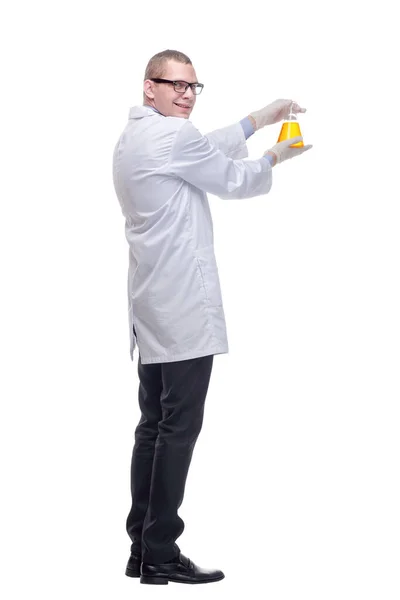 Kemist som håller upp bägare av gul kemikalie i laboratoriet — Stockfoto