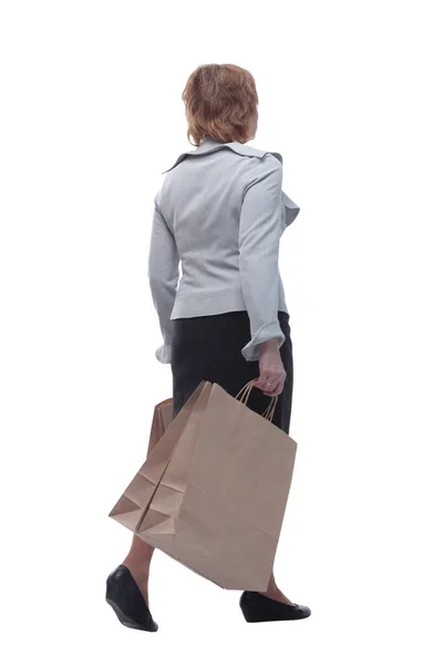 Vista posterior retrato de longitud completa de una mujer mayor caminando con bolsas de compras — Foto de Stock