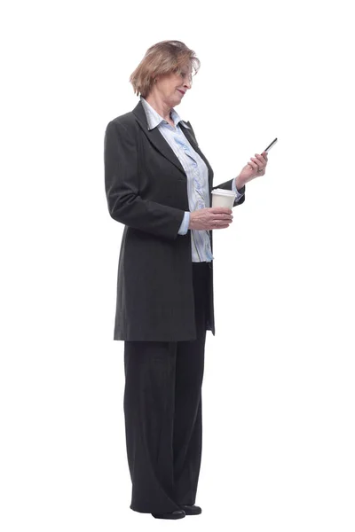 Dame souriante senior est debout avec téléphone intelligent dans les mains et une tasse de café — Photo