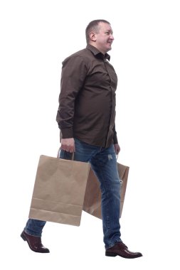 Yan görünüş. Alışveriş çantalı mutlu adam eve yürüyor. .