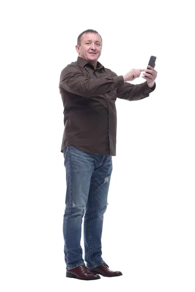 V plném růstu. usmívající se dospělý muž se dívá na obrazovku svého smartphonu. — Stock fotografie
