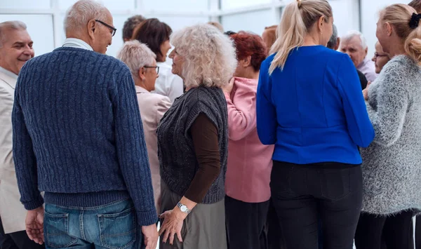 Un groupe de personnes âgées debout le dos à l'intérieur — Photo