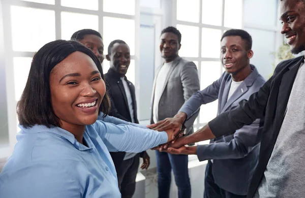 Joven mujer de negocios y sus colegas están mostrando su unidad . —  Fotos de Stock