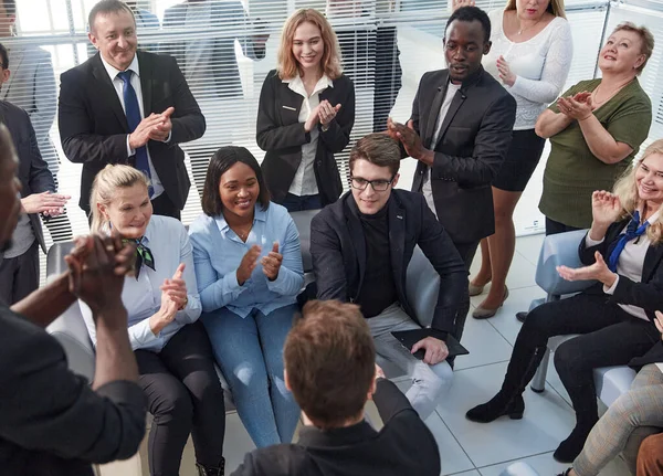 Kantoormedewerkers zitten op stoelen klappen handen begroeting presentator of spreker op groepsvergadering close-up. — Stockfoto