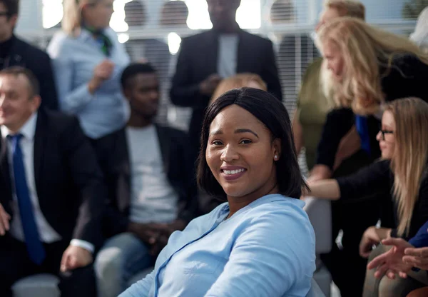 Jovem mulher negra sorrindo para a câmera no escritório — Fotografia de Stock