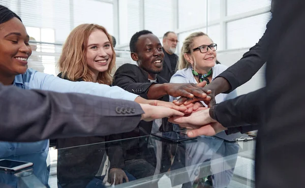 Ondernemers stapelen handen op in vergadering op kantoor — Stockfoto