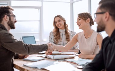 İş adamı iş ortaklarının el sıkışmasına bakıyor